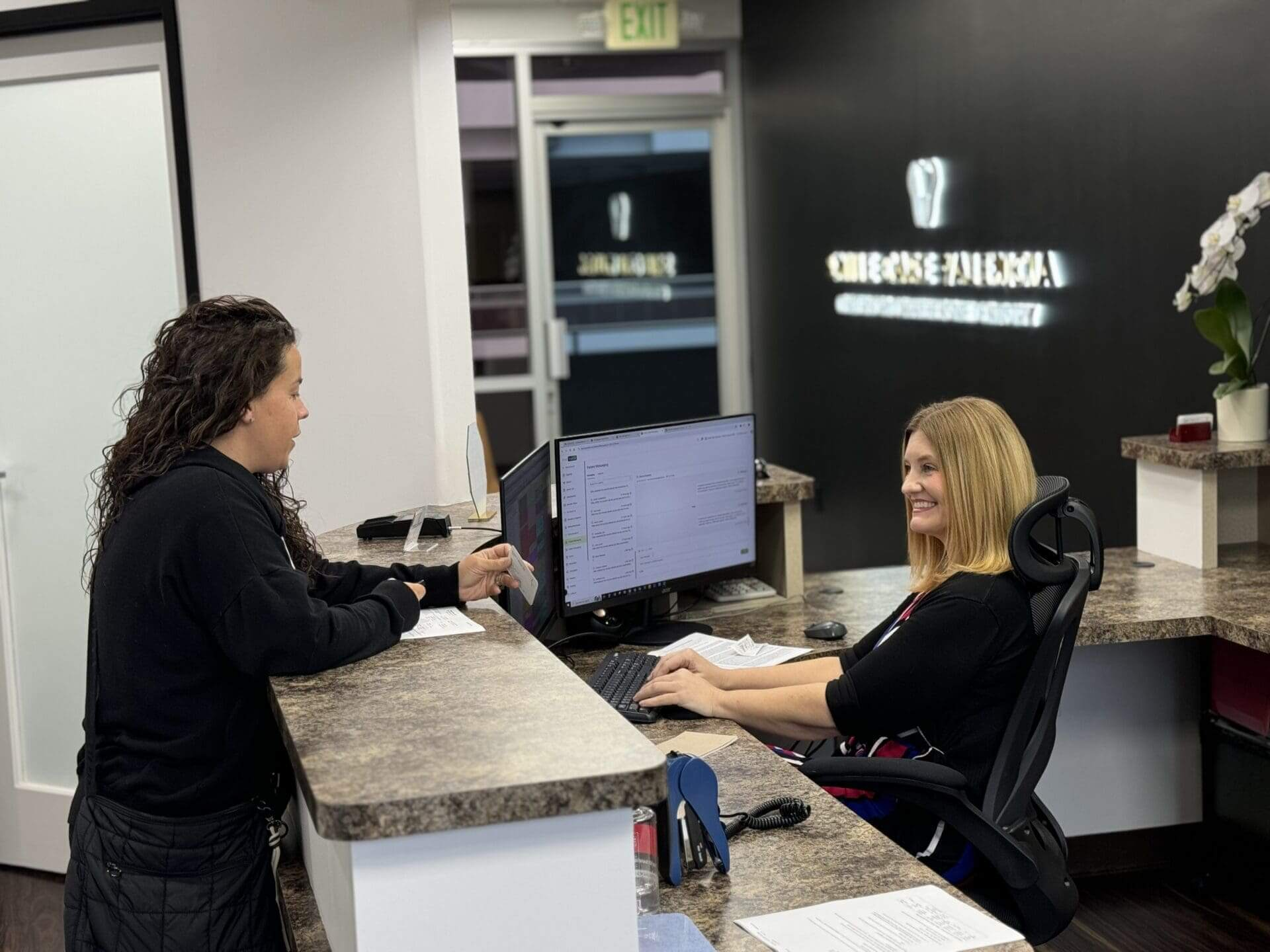 Friendly front desk team checking in a patient